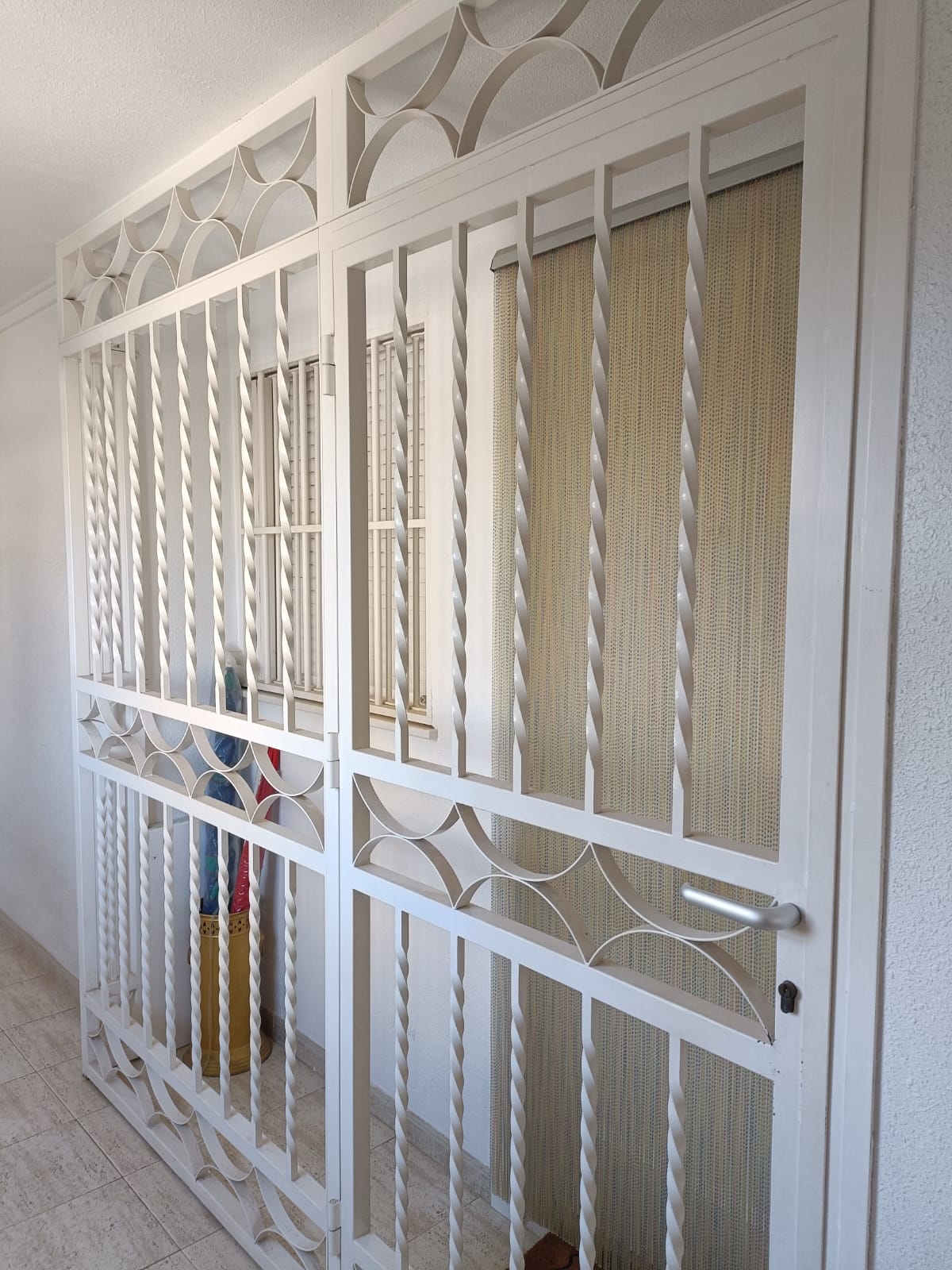 Reja decorativa blanca con puerta