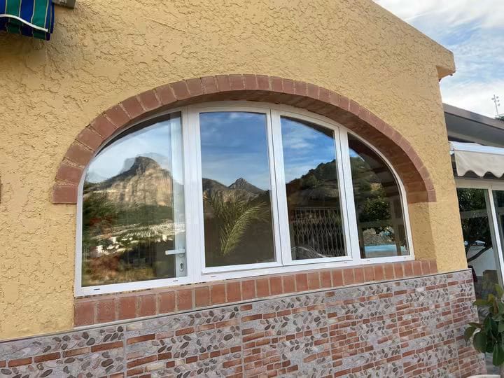 Ventana de aluminio blanca adaptada a un arco